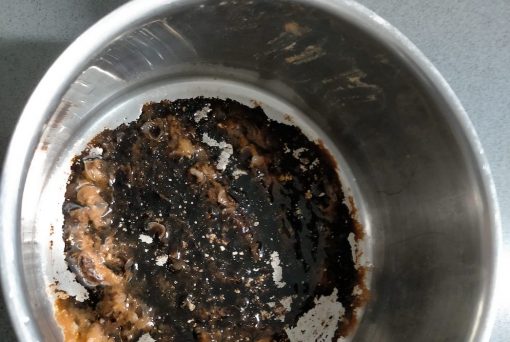 How to clean a burnt pot - an image illustrating burn on food in the bottom of a stainless steel pot